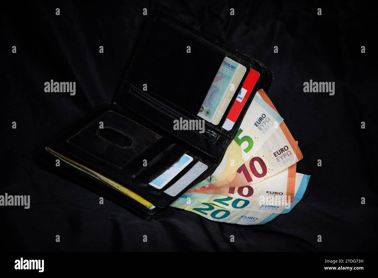 Brieftasche mit Geld und Dokumenten vor schwarzem Hintergrund Stock Photo