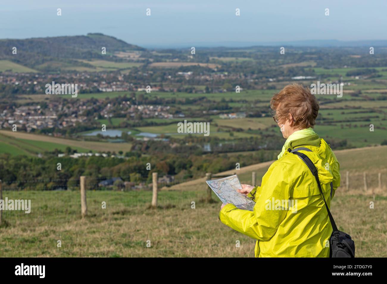 Woman checking map, in the background Upper Beeding and Steyning, Truleigh Hill, Shoreham by Sea, South Downs, West Sussex, England, Great Britain Stock Photo