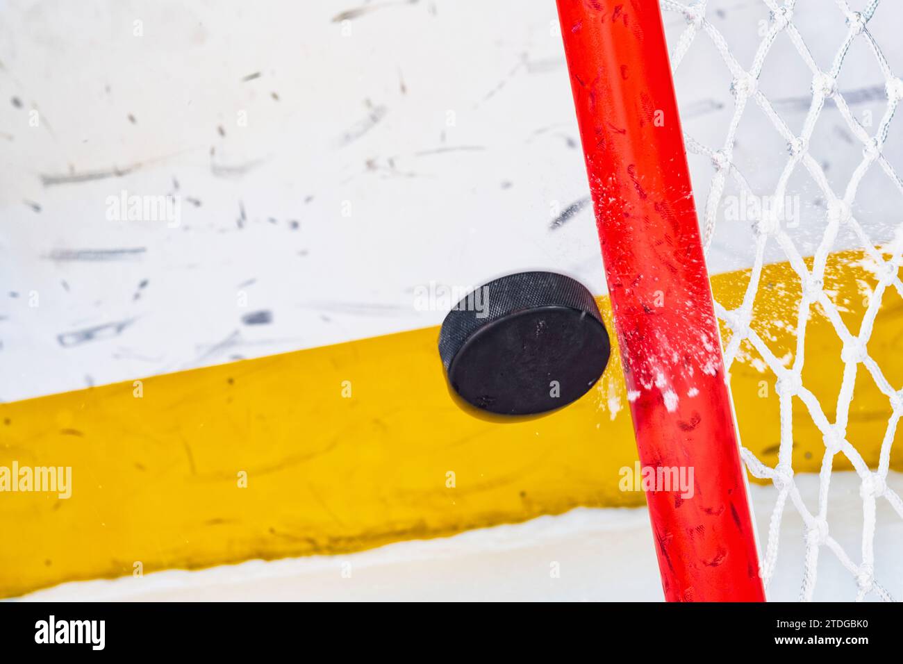 An ice hockey puck in midair hitting the goal post Stock Photo Alamy