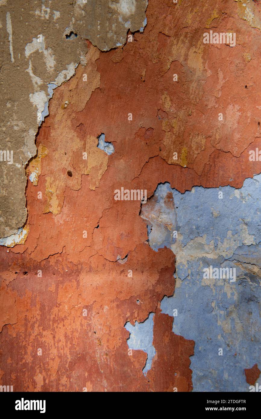 Detail of the colorful, textured exterior wall of an old, painted