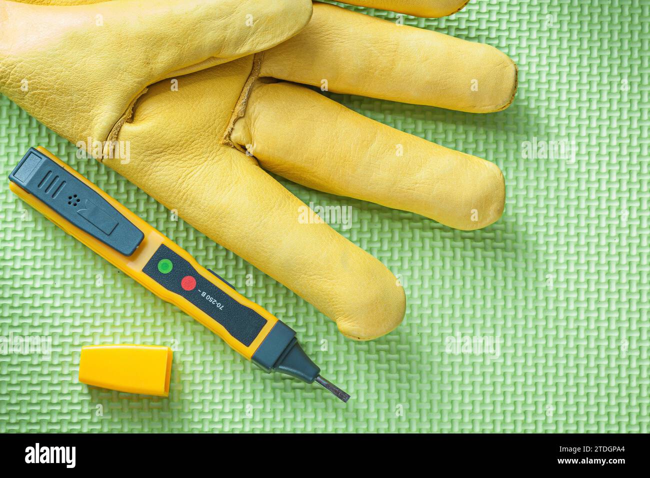 Leather safety glove electrical tester on green background electricity