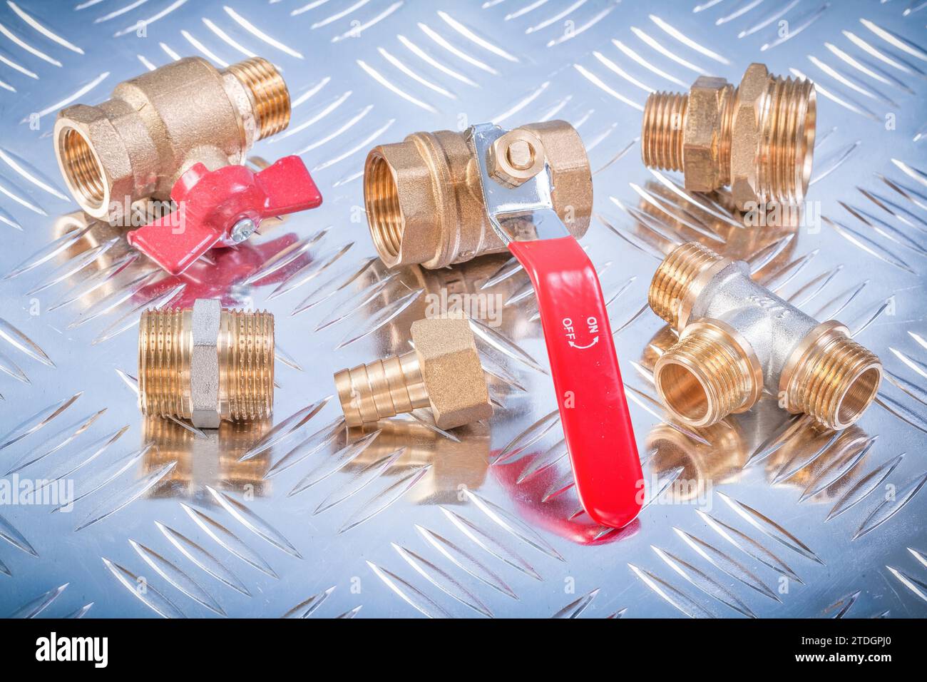 Brass nipple hose connectors equal tee check water valves on channeled metal plate plumbing concept Stock Photo
