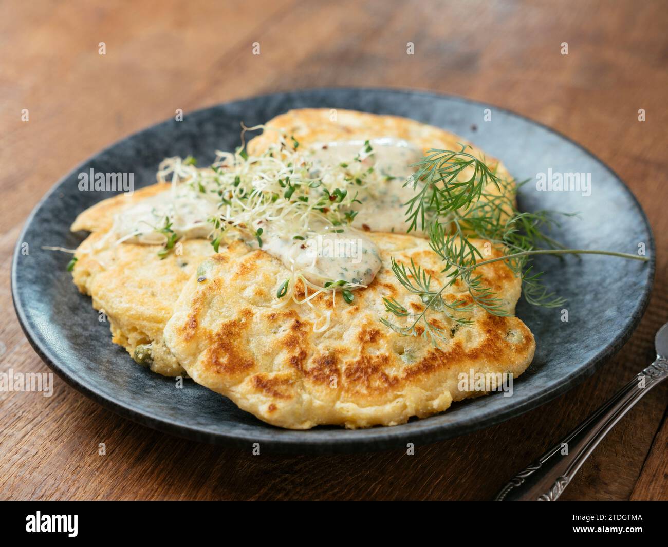 Savory pea pancakes with a chives and herbed sauce Stock Photo