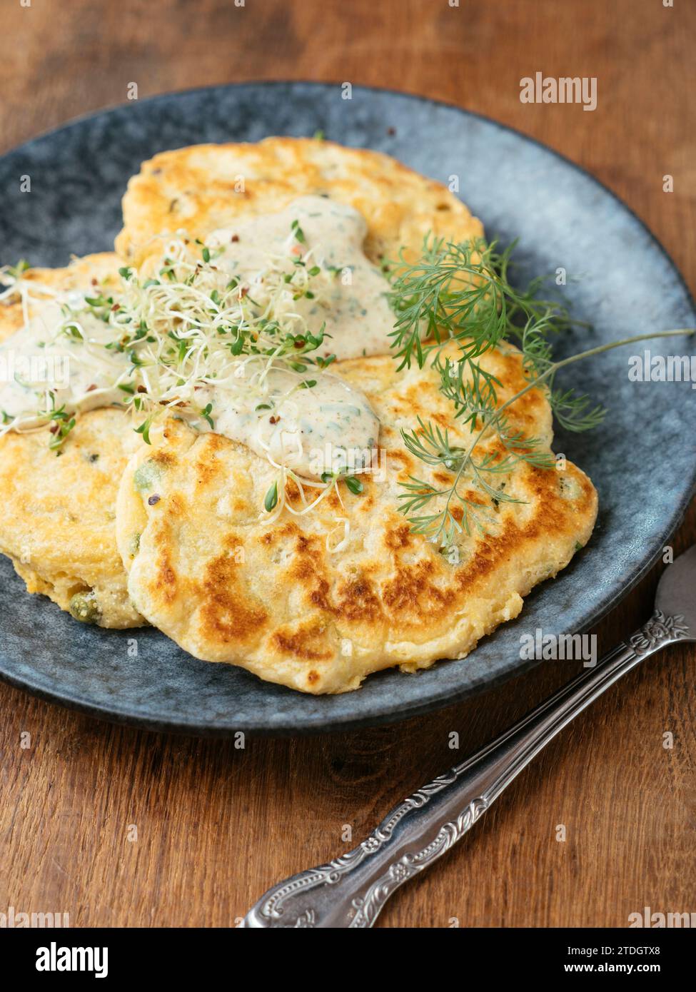 Savory pea pancakes with a chives and herbed sauce Stock Photo