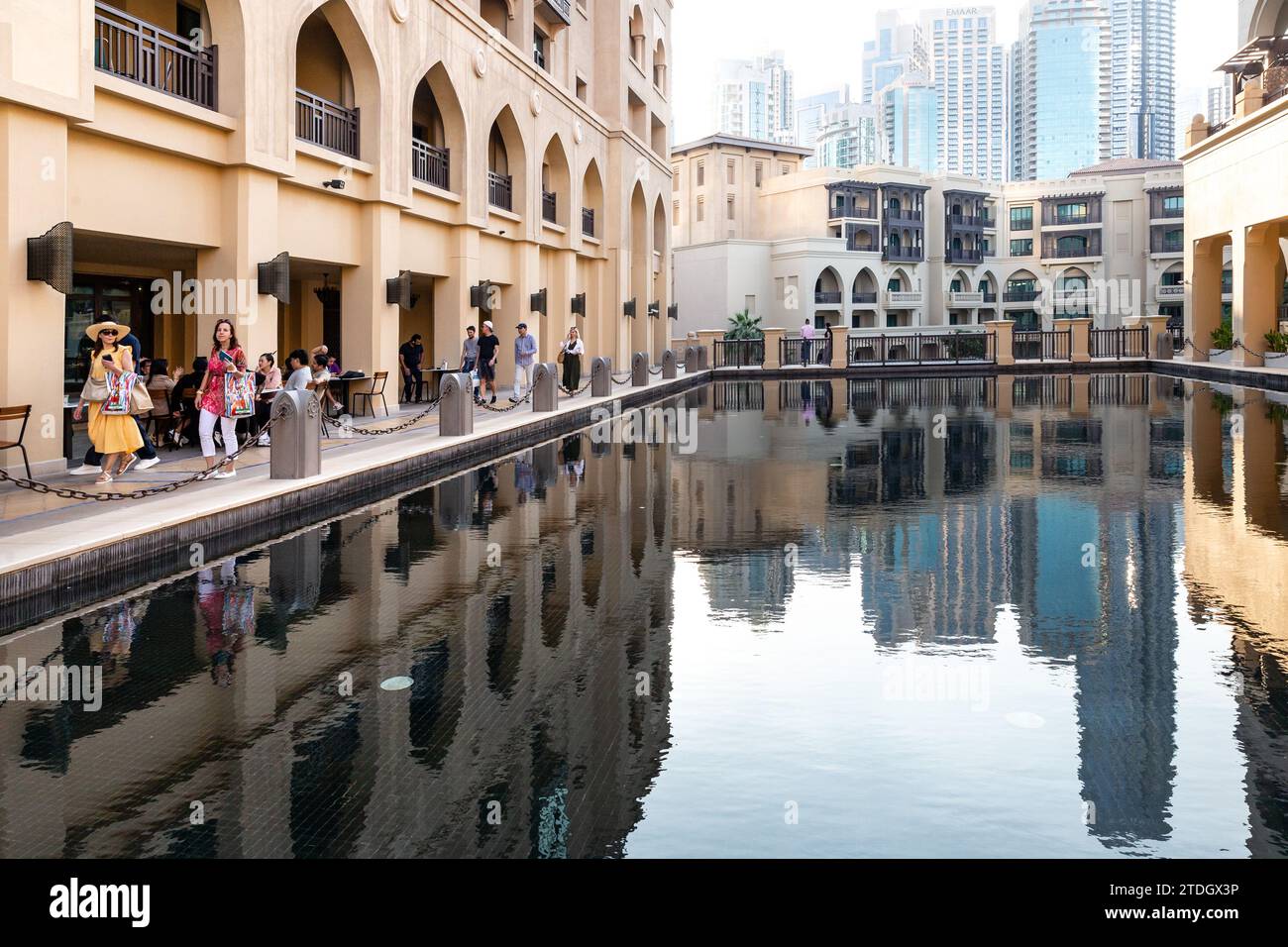 Dubai, United Arab Emirates. 18th Dec, 2023. Visitors walk by the buildings of Dubai old town, Souk al Bahar and modern architecture of the centre of the city is seen against the water of The Dubai Fountain on a hot December day. Credit: Dominika Zarzycka/Alamy Live News Stock Photo