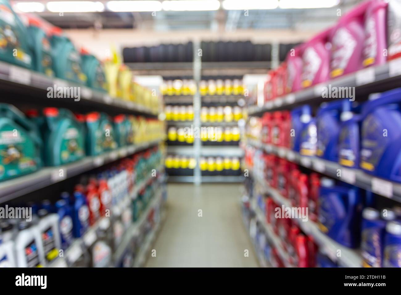 Blurred colorful motor oil bottles on shelves in specialized store