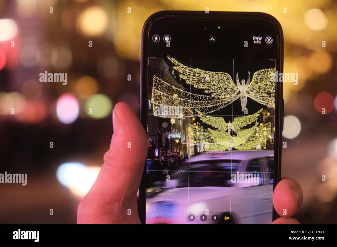 Close-up of a mobile phone photographing the Christmas lights on Regent's Street at night. Stock Photo