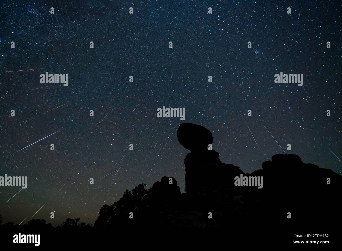 Geminid Meteor Shower over Balanced Rock in Arches National Park in Utah.  Composite image shows 24 meteorites over a 2-hour period. Stock Photo