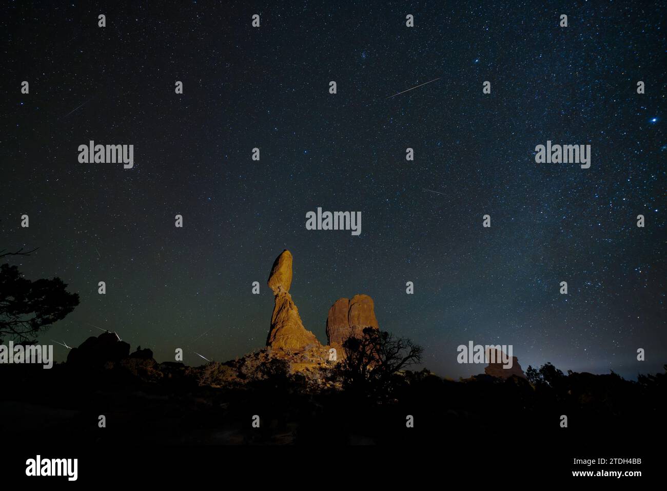 Geminid Meteor Shower over Balanced Rock in Arches National Park in Utah.  Composite image shows 10 meteorites over a 2-hour period. Stock Photo