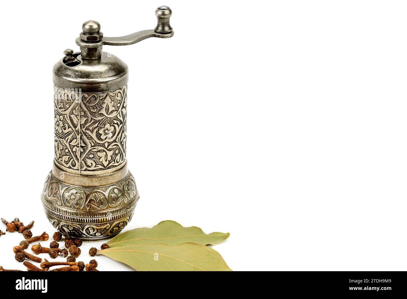 Manual grinder, clove spice and laurel isolated on white background