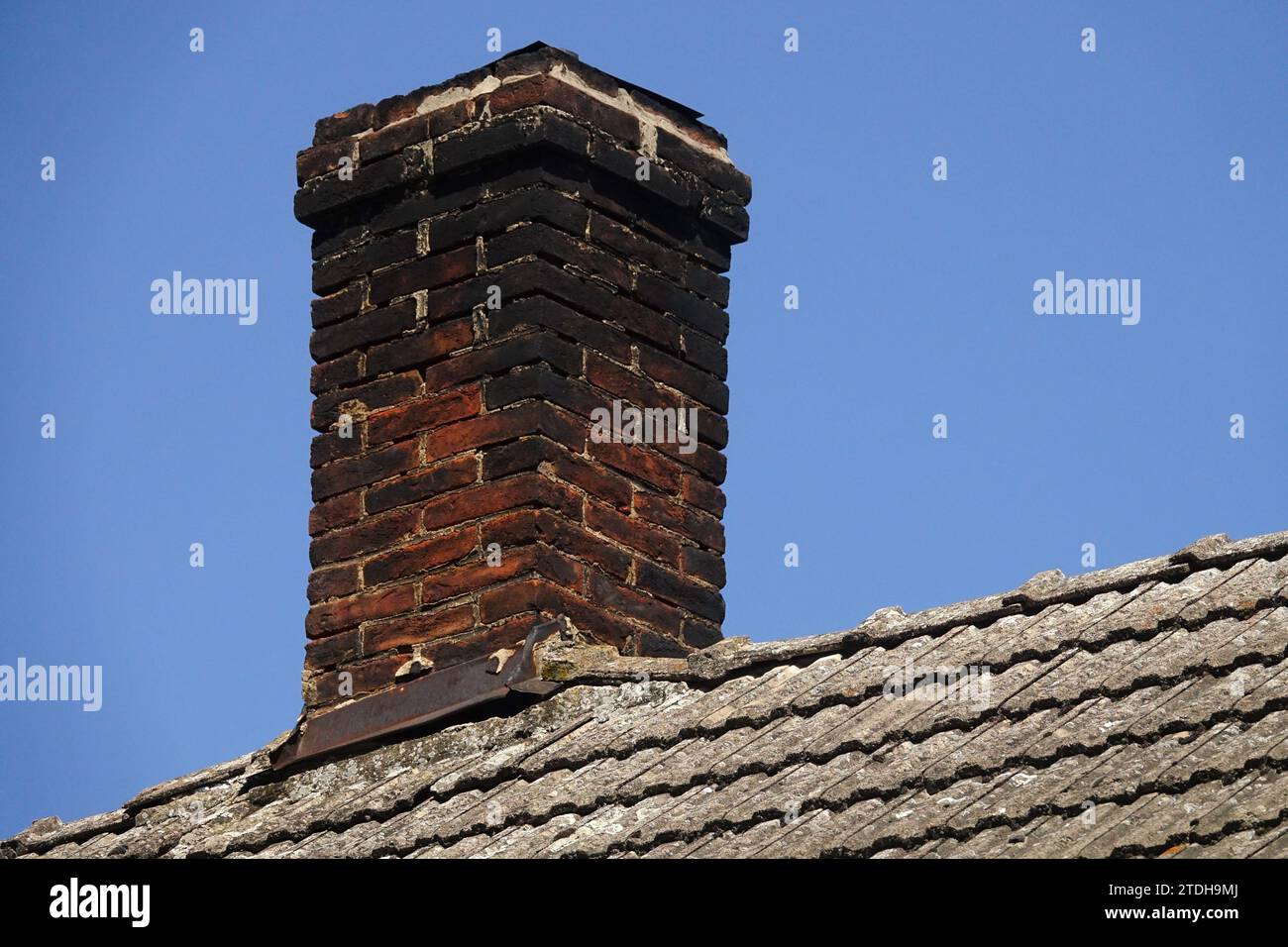 brick chimney on tile roof Stock Photo