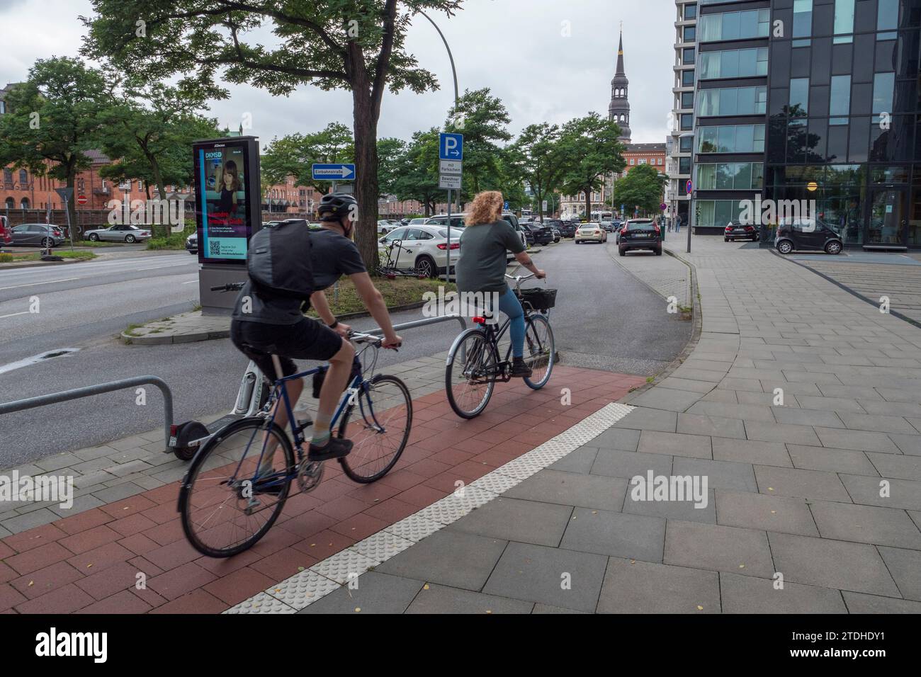 Cyclists on the red banded cycle lane on a footpath in Hamburg, Germany ...