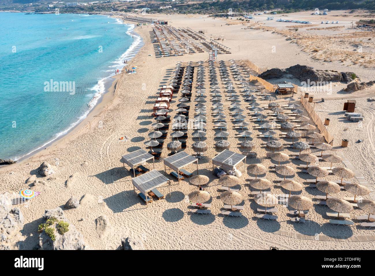 Falassarna sandy beach, Crete island Greece. Aerial drone view of umbrella, seaside sun bed, wavy sea water, summer famous resort vacation. Stock Photo