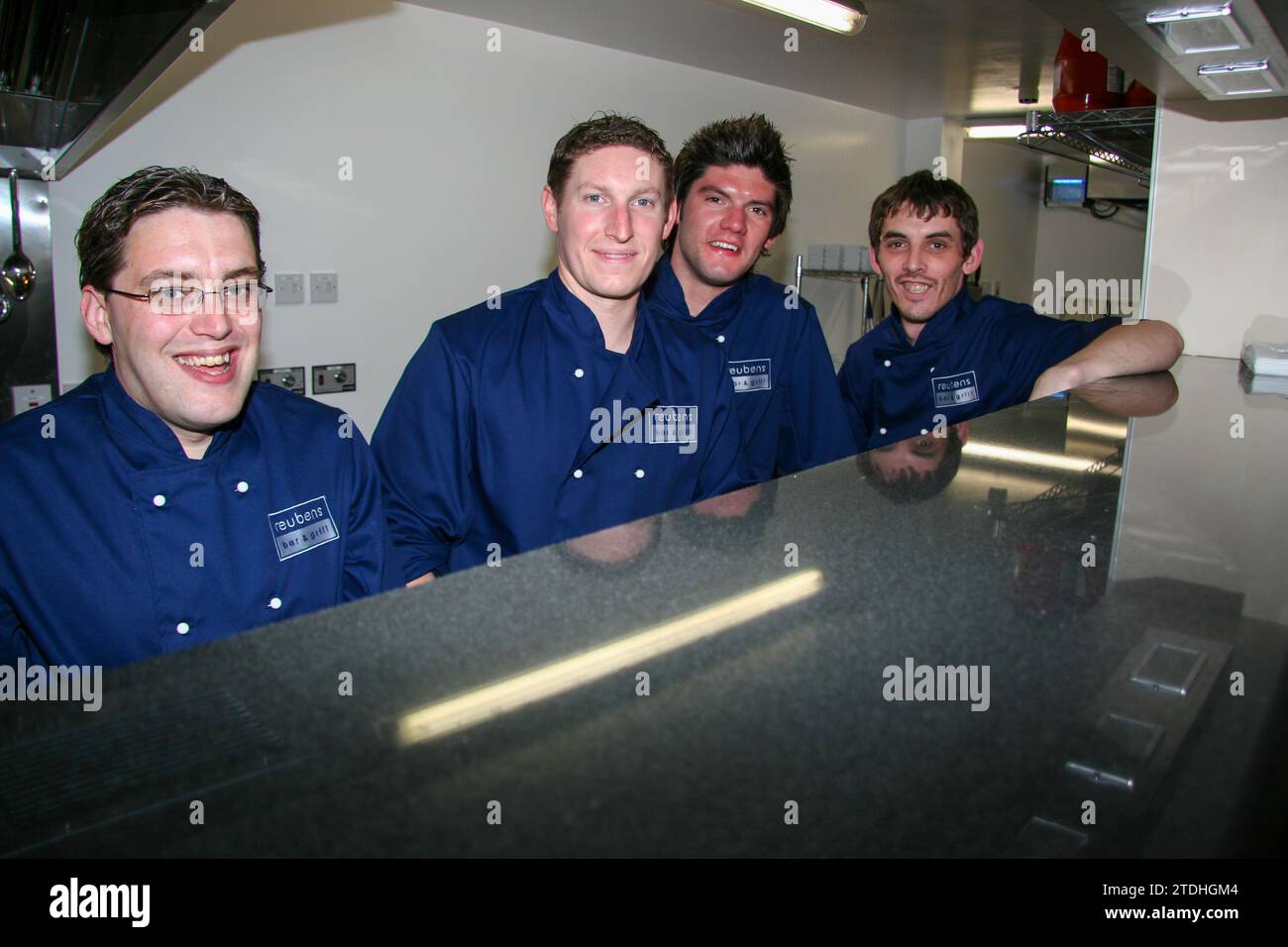 A quartet of chefs in their new dark blue uniforms look out from the ...
