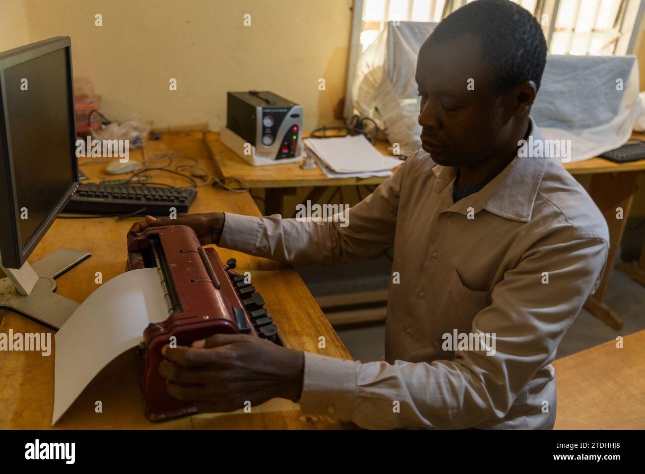 A blind person during typing work on a special braille typewriter. Stock Photo