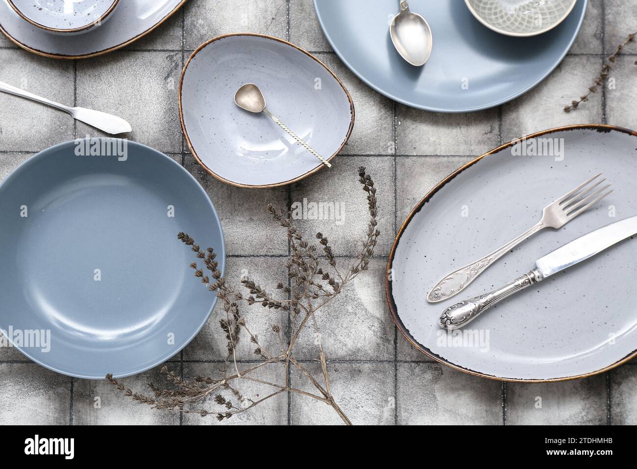 Beautiful table setting with ceramic plates, cutlery and dried floral
