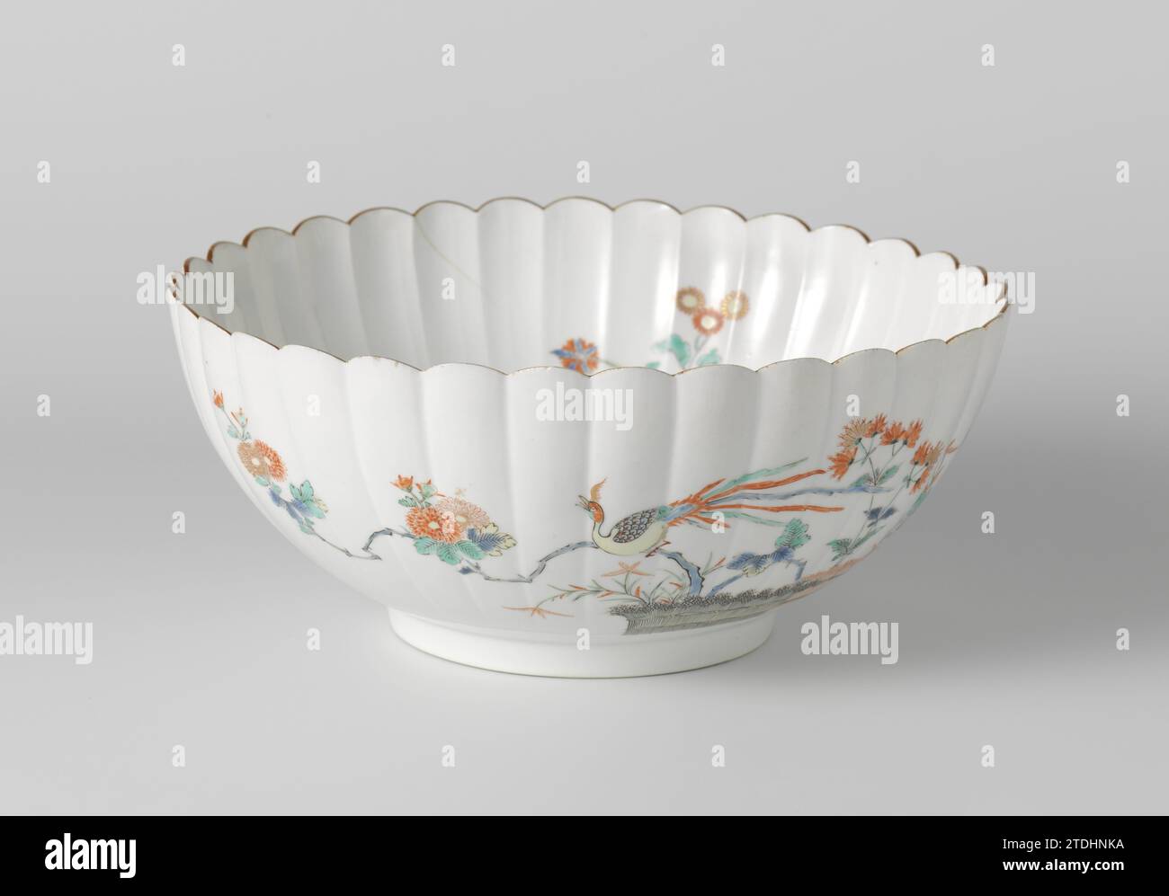 Petalled bowl with brushwood fences, mistflower, chrysanthemum en hoo, anonymous, c. 1670 - c. 1690 Come, with ribbed wall of 33 ribs, painted on the glaze in blue, red, green, yellow, black and gold, with a Hoo bird on a chrysanthemum on a chrysanthemum in bound hedges and liver herb (Fujibakama, Eupatorium Fortunei ); On the other hand, liver herb and a flying Hoo-Vogel. On the inner wall three equal flower branches and on the bottom two Hoo birds in circular shape. Brown edge. A crack in the wall; A chip in the edge. Old label on the bottom with 'Collection Westendorp/ 108'. Kakiemon. Japan Stock Photo
