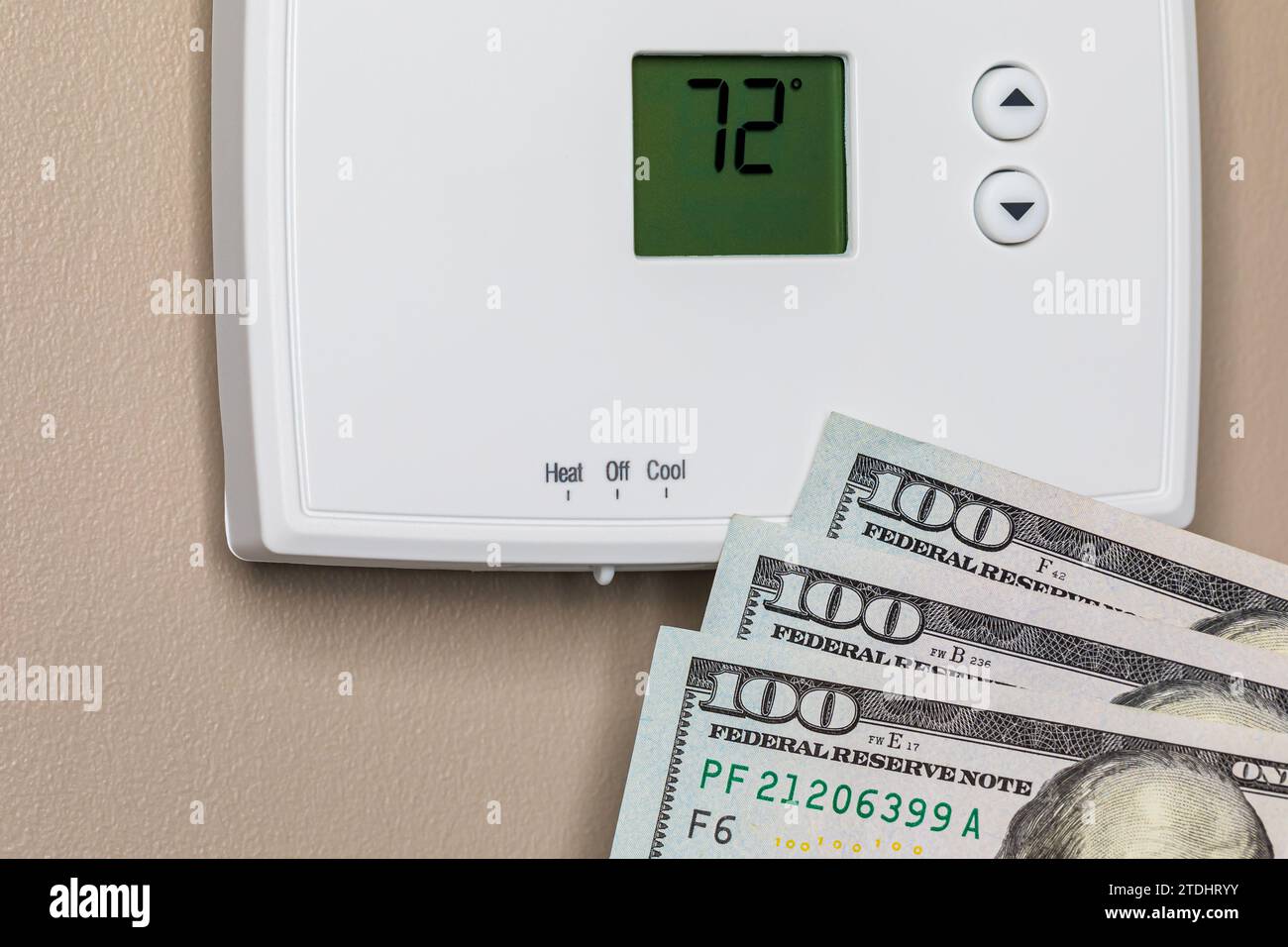Thermostat for home furnace and air conditioner with cash money. Utility bill savings, energy cost and conservation concept Stock Photo
