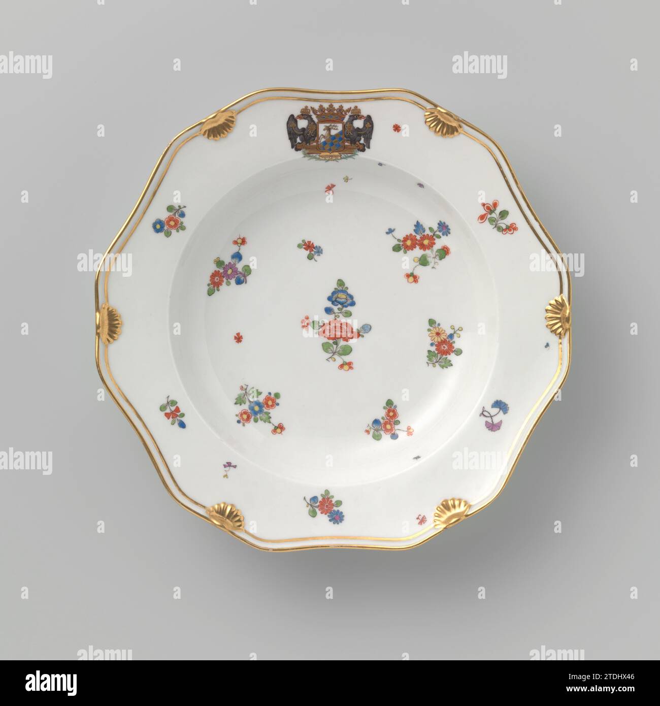 Plate with the Coat of Ams of Count Heinrich von Podewils and Flower Sprays, royal porcelain manufactory, c. 1763 - c. 1800 Twelve -angled plate of porcelain, painted on the glaze in blue, red, pink, green, yellow, black and gold. On the flat, wall and the edge of flower branches and sprinkling flowers in the style of Japanese Kakiemon porcelain. The crowned weapon of Count Heinrich von Podewils (1695-1760) on the edge. Along the edge a double gold line interrupted by six shell motifs. The back with four scatter flowers. Marked on the bottom with the scepter and number 23. Berlin porcelain. gl Stock Photo