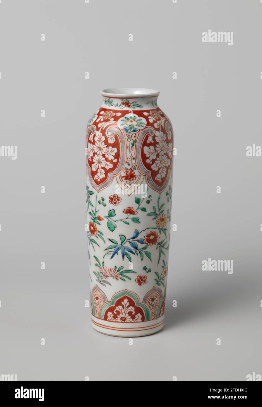 Cilindrical vase with flower sprays and scrolls in shaped panels, anonymous, c. 1700 - c. 1725 Cylindrical vase of porcelain with a wide, slightly spreading neck, painted on the glaze in blue, red, green, yellow, eggplant, black and gold. On the wall loose flower branches. Around the foot and on the shoulder a band with scalloped cartouches or lambrequins with flower branches and vines. On the shoulder the tire is interrupted by four lobed cartouches with a flower branch. The neck with flower branches. Imari. Japan porcelain. glaze. gold (metal) painting / gilding / vitrification Cylindrical v Stock Photo