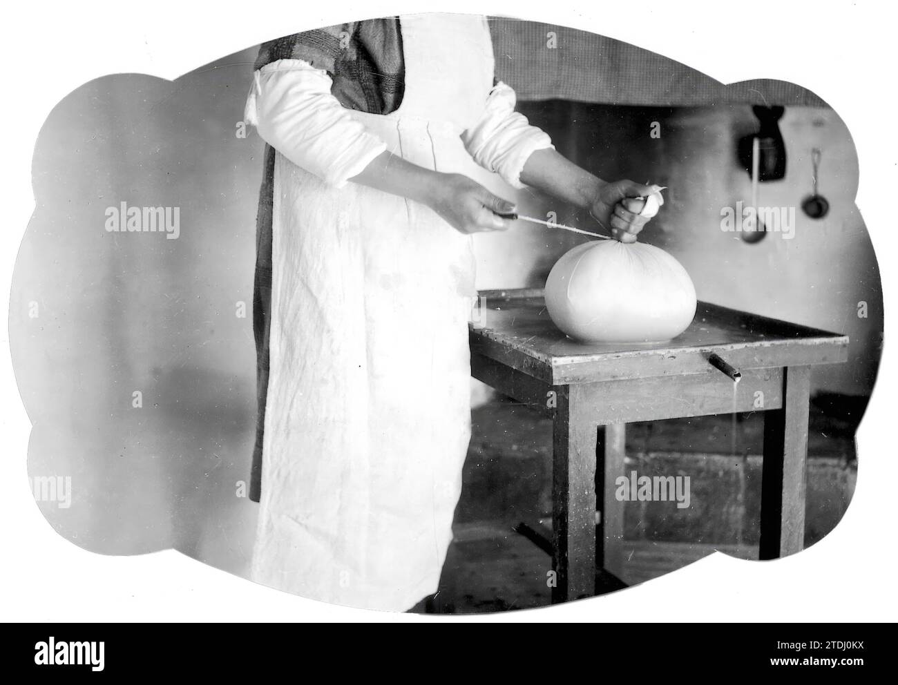 01/01/1930. Artisanal cheese preparation in a cheese factory from the