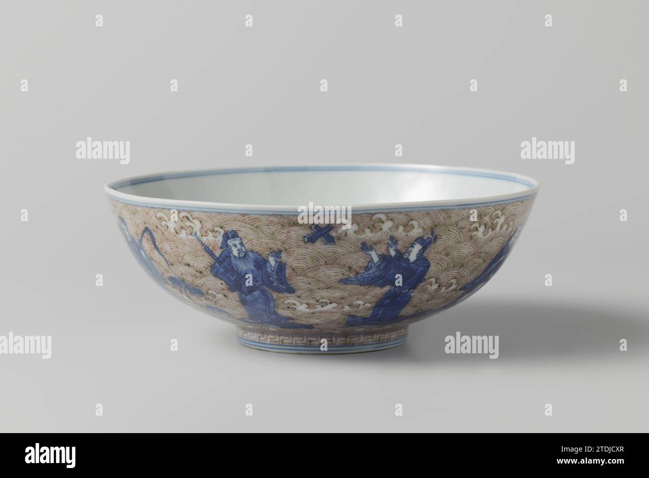 Bowl with the eight immortals and Shoulao, anonymous, c. 1875 - c. 1899 Come from porcelain with a flared wall, painted in underly glaze blue and red. On the outside the eight immortales standing on marine animals, against a background of foaming waves; On the bottom shouldlao with a deer with a mushroom in his mouth against a background of foaming waves and clouds; Around the foot ring a decorative edge with a meander motif. On the underside the six-character brand Chenghua in a double circle and an old label with 'Marked Ching-Hua period 1465-1488 1888 A. Trapnell'. Underglaze blue with copp Stock Photo