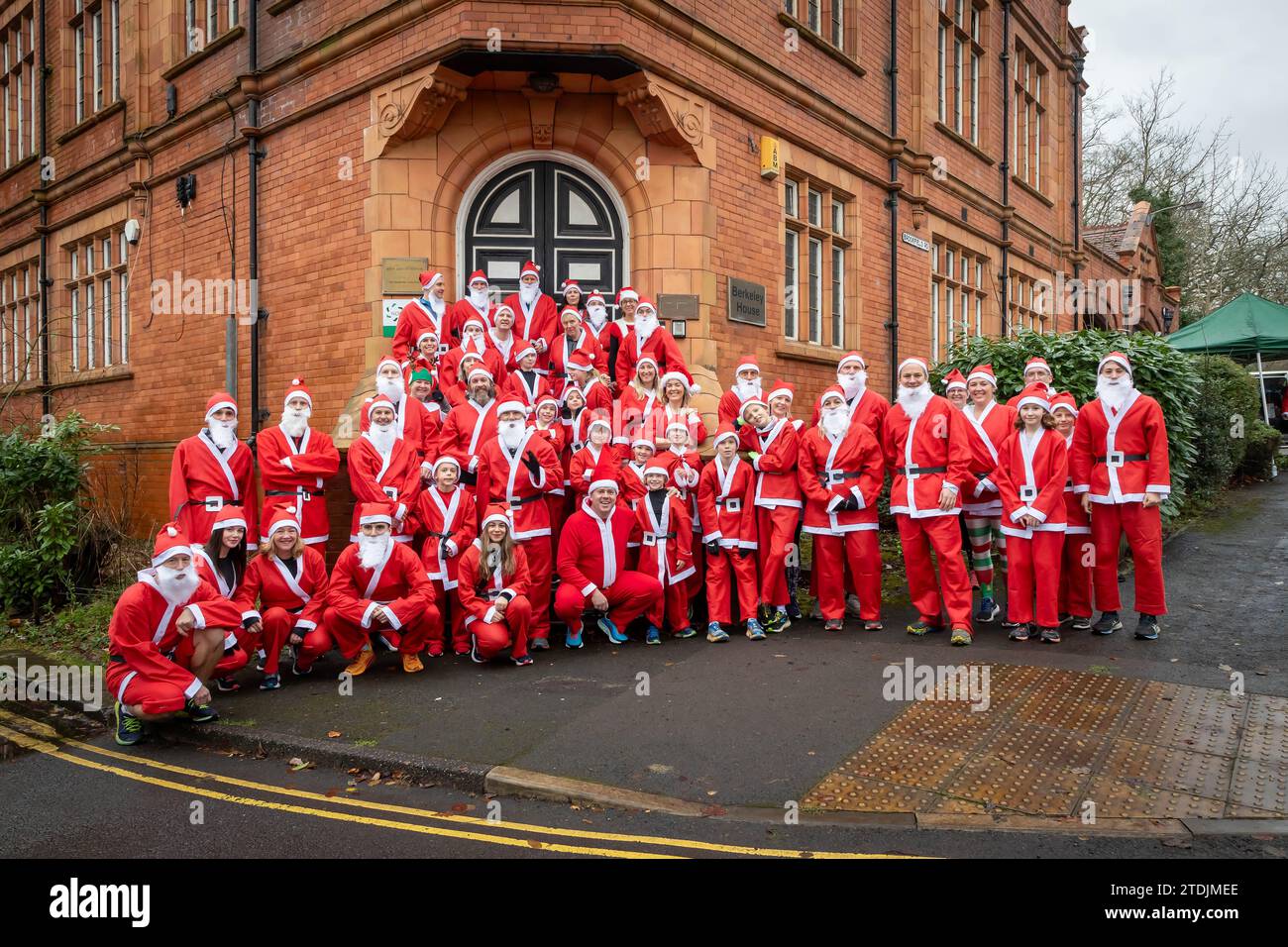 The 2023 Santa Dash ran through the village of Lymm, Cheshire, at the Dickensian Day Festival. A lot posed on steps for a photo Stock Photo