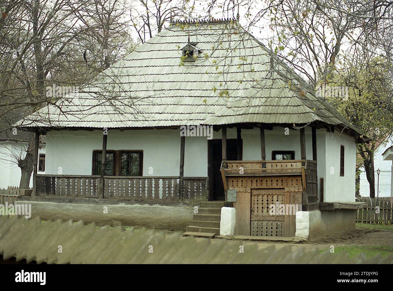 The Village Museum, Bucharest, Romania, approx. 2000. Traditional house from Prahova County with wooden porch and roof and beautifully ornate entrance to the cellar. Stock Photo