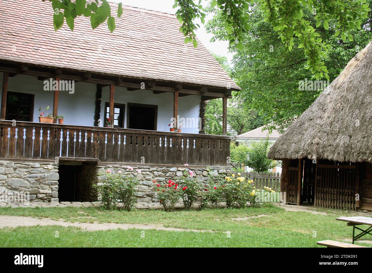 The Village Museum, Bucharest, Romania. Authentic 19th century house from Transylvania, with sculpted wooden porch, river rocks foundation and cellar. Stock Photo