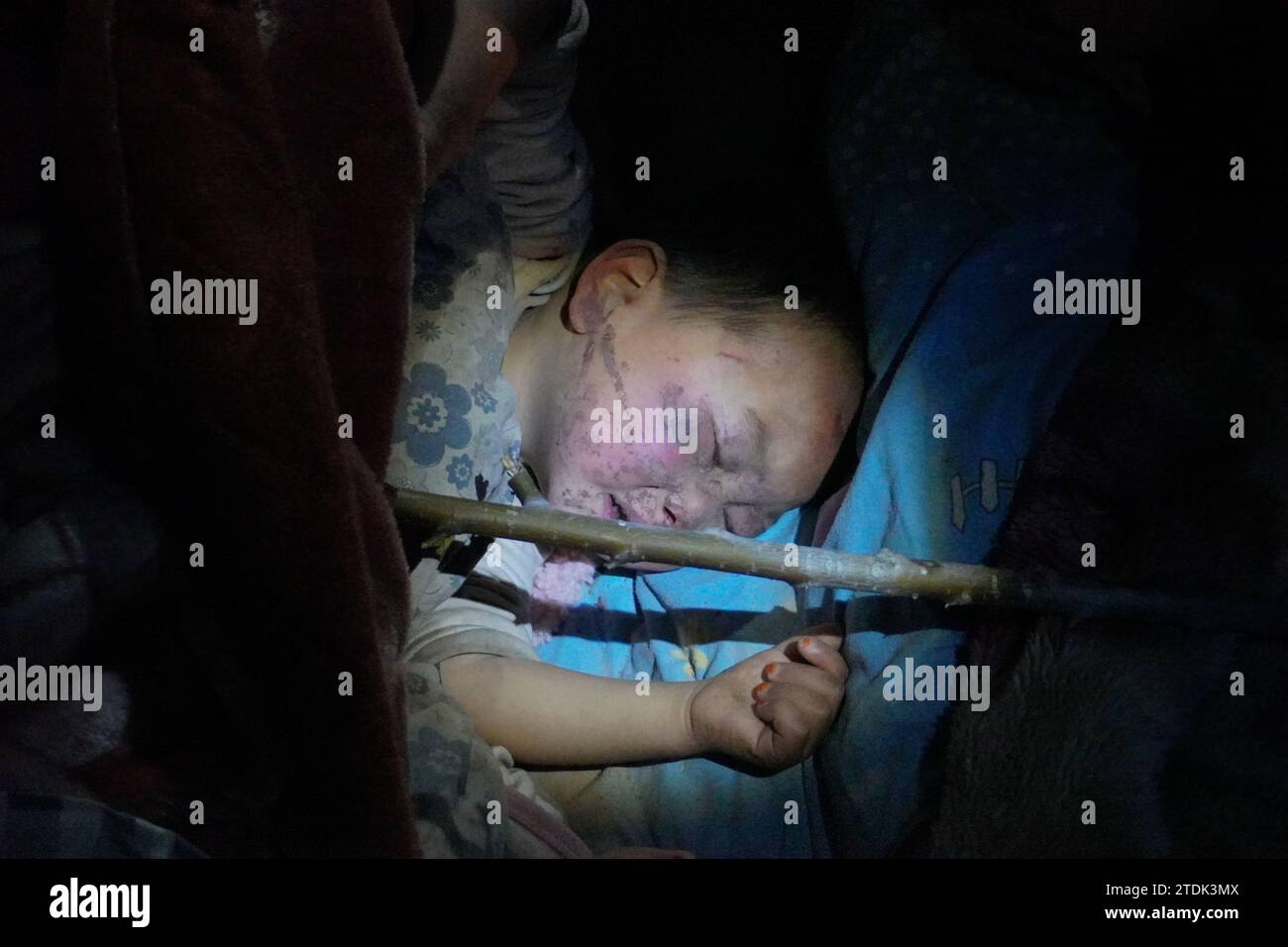 Jishishan, China. 19 December, 2023. A child injured in an earthquake falls asleep after being treated and settled at a hospital in Jishishan Bao'an, Dongxiang, Salar Autonomous County in Linxia Hui Autonomous Prefecture, northwest China's Gansu Province, Dec. 19, 2023. The 6.2-magnitude earthquake that jolted an ethnic county in northwest China's Gansu Province midnight Monday has killed 105 people in Gansu Province. The provincial fire and rescue department has sent 580 rescuers aided with 88 fire engines, 12 search and rescue dogs, more than 10,000 sets of equipment to the disa Stock Photo
