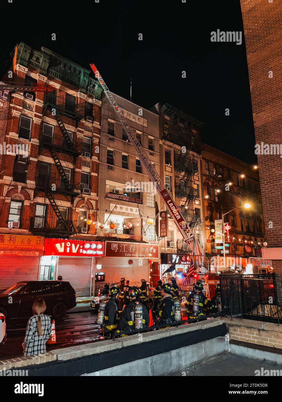 an FDNY truck applies a ladder to a building on Bayard Street, in New York's Chinatown, while fighting a fire Stock Photo