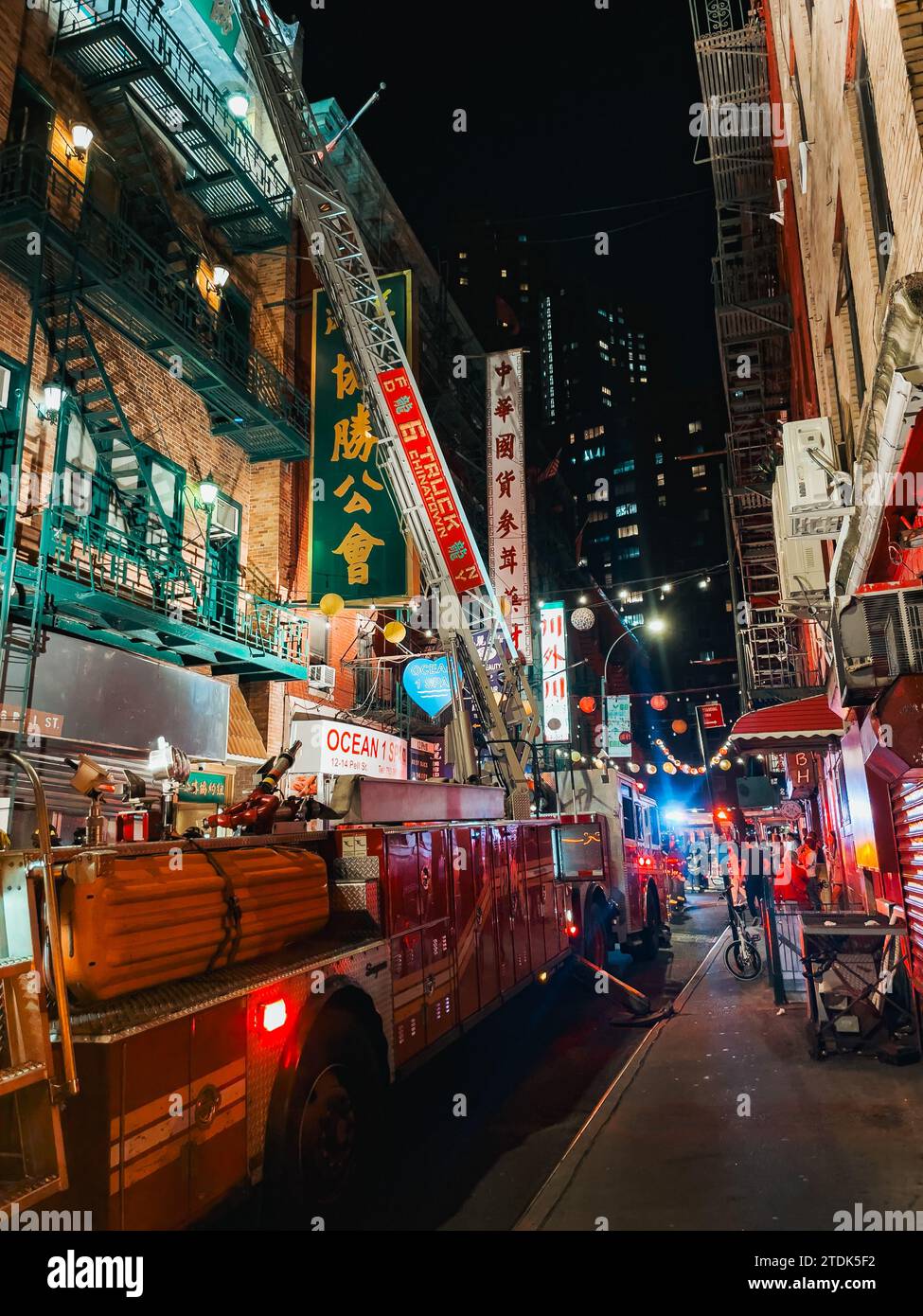 a FDNY fire truck with its ladder extended against an apartment building in Chinatown, New York, while attending a fire Stock Photo