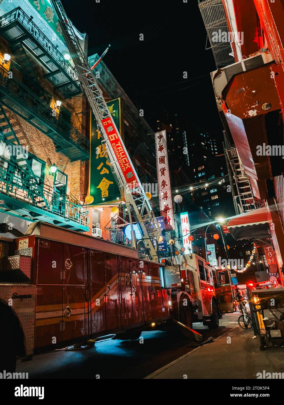 a FDNY fire truck with its ladder extended against an apartment building in Chinatown, New York, while attending a fire Stock Photo