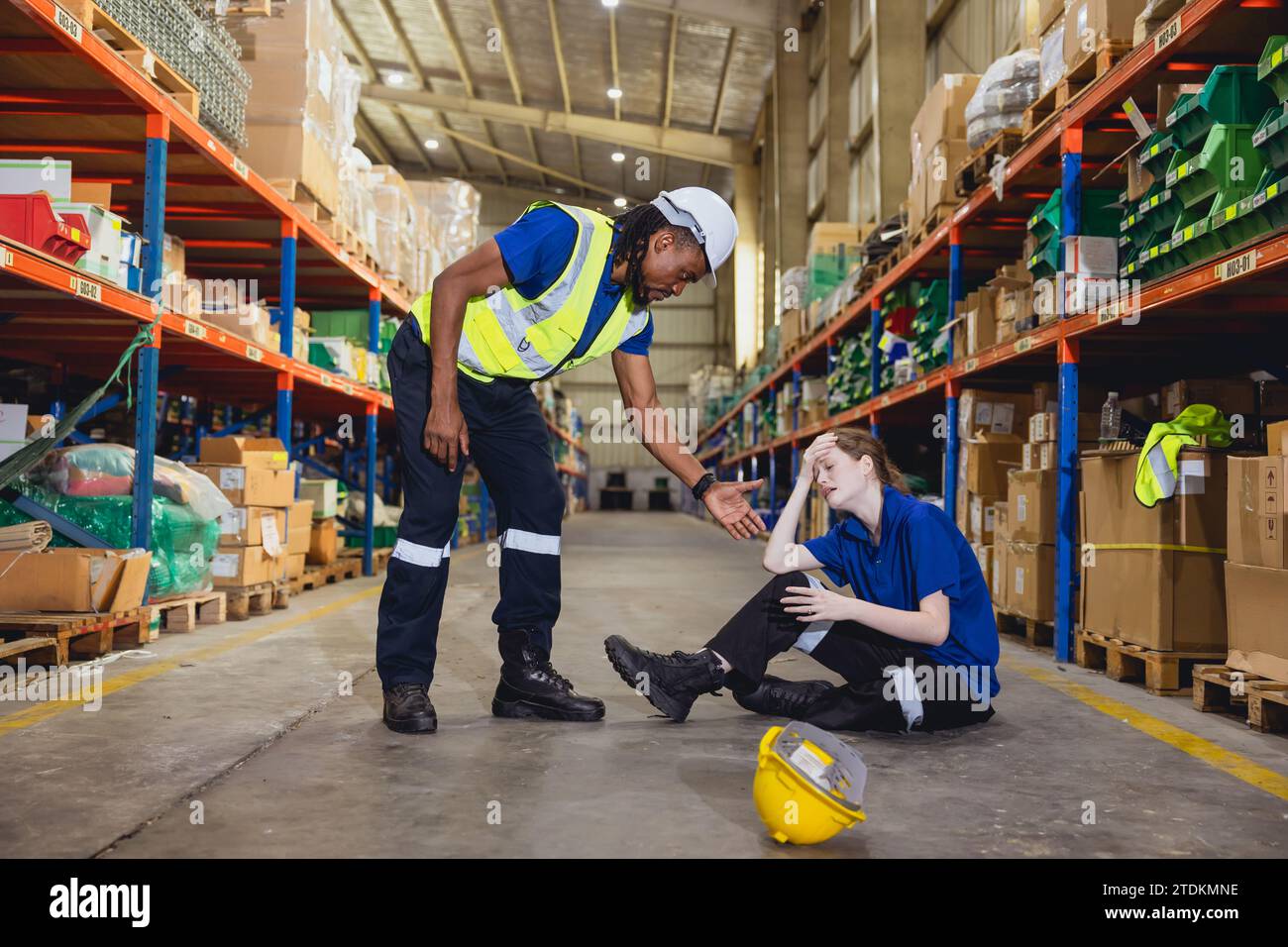 Young new warehouse women worker falling accident injury and hurt girl crying friend help reaching hand and motivate her. Stock Photo