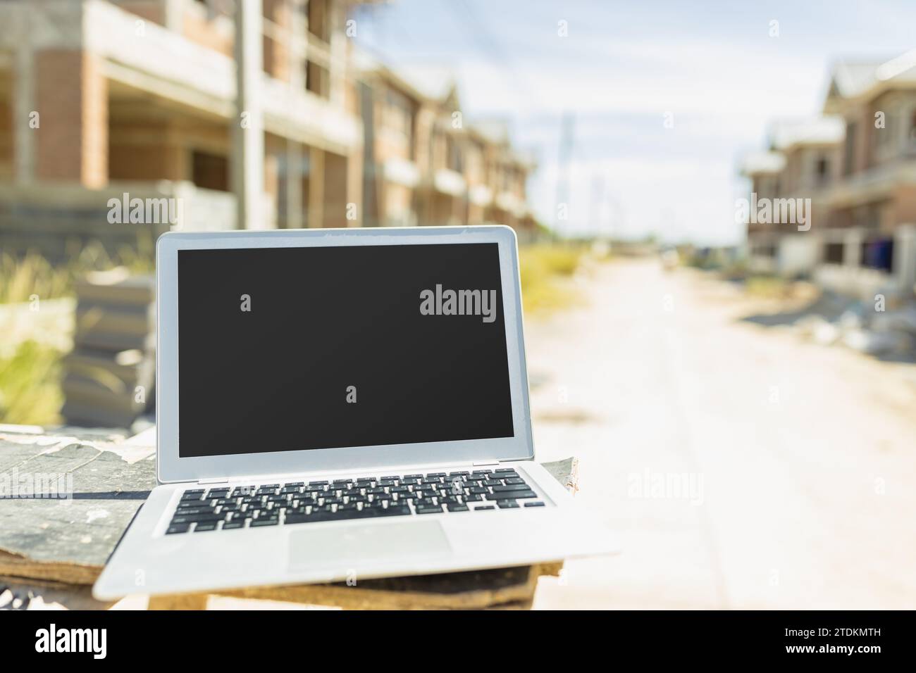 Computer laptop blank screen in construction site background for advertising builder engineer architect software design technology device. Stock Photo