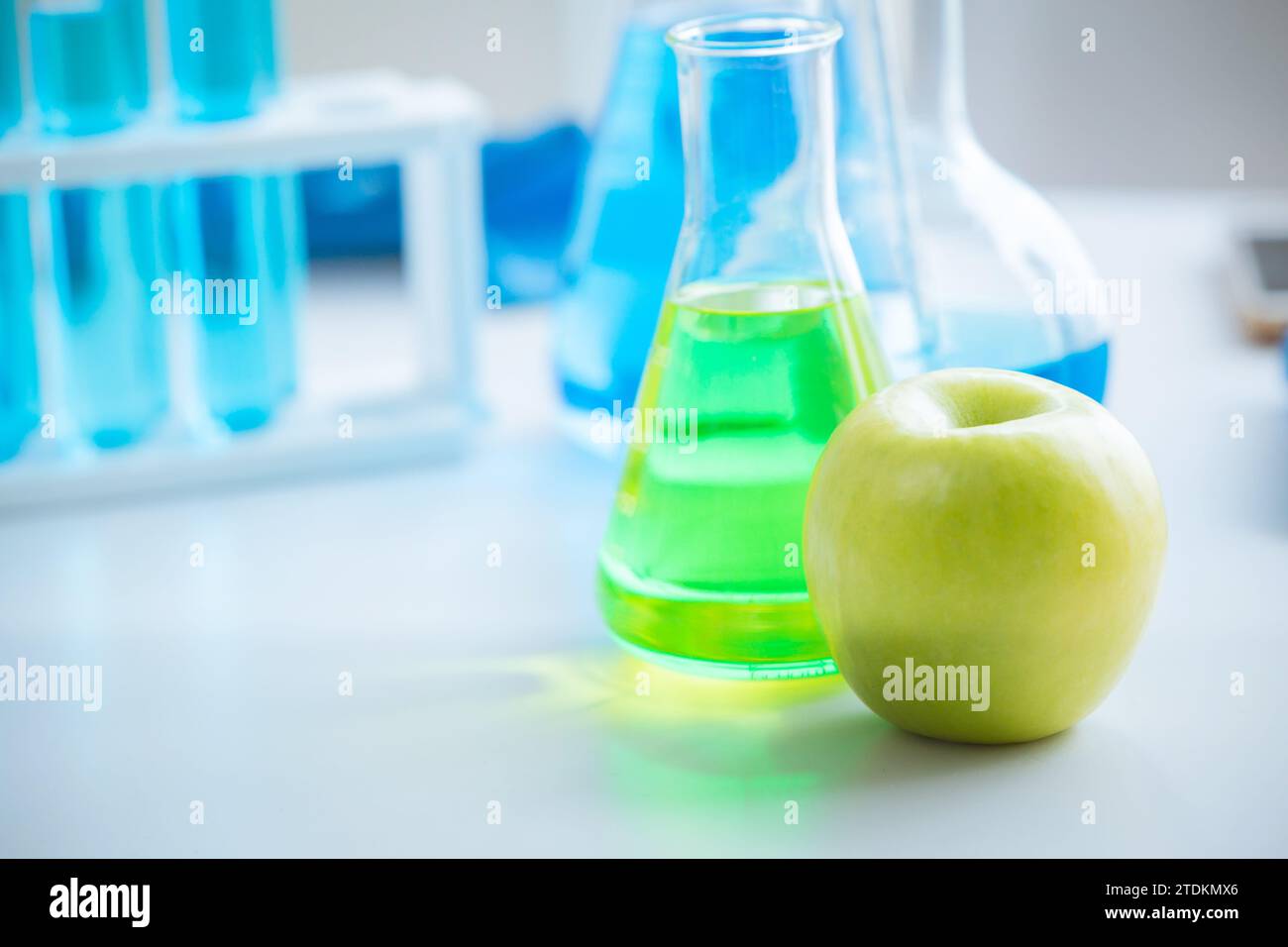 Green Apple in food science lab for high antioxidant bio flavonoid vitamin C nutrition healthcare extraction from fruit. Stock Photo