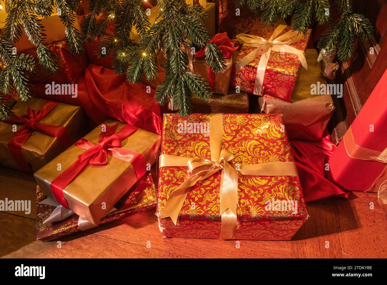 Christmas presents or gifts under the Christmas tree wrapped in colourful wrapping paper with ribbons Stock Photo