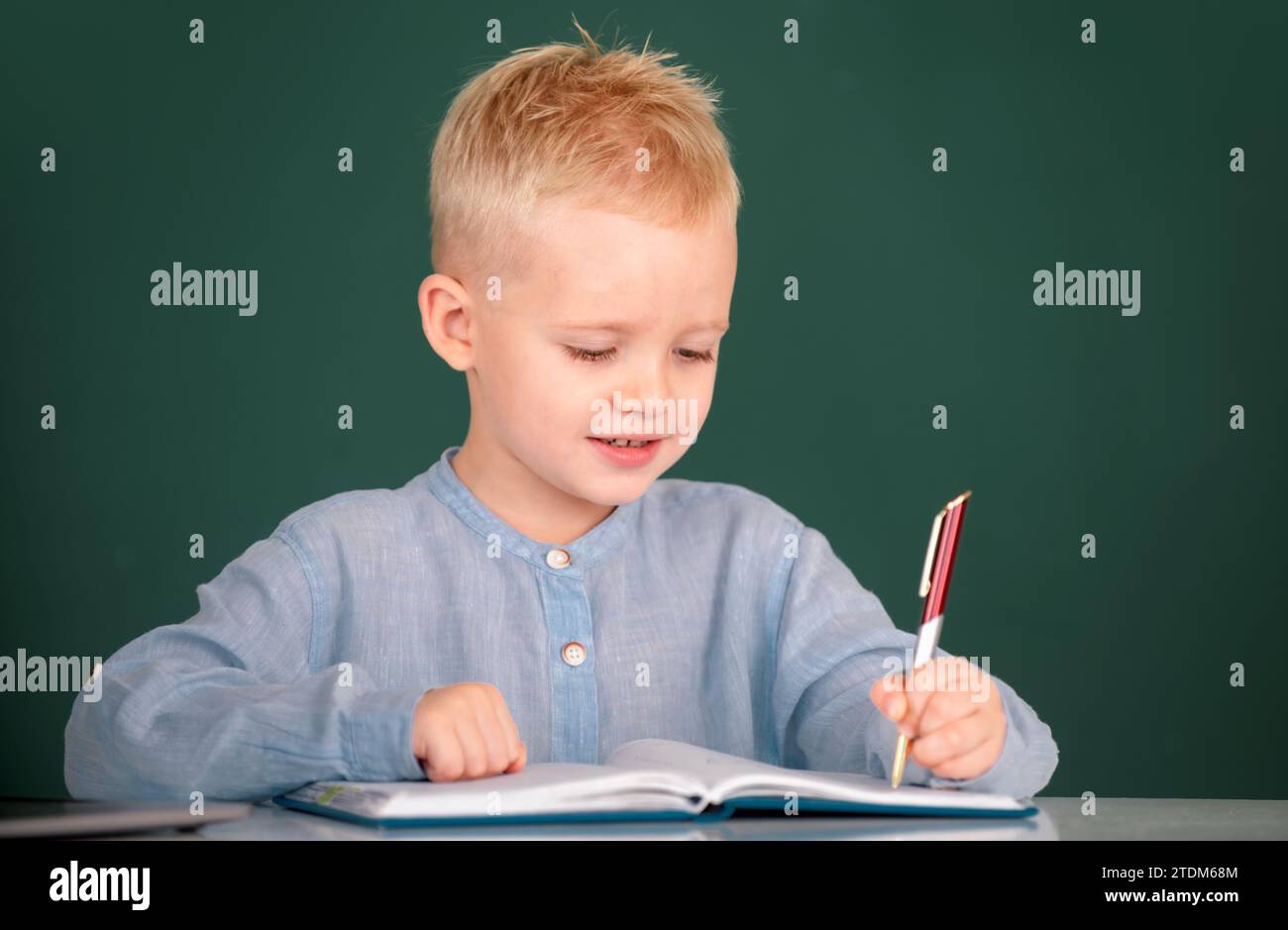 Kid Writing Down Math Math Kid writing in class. School boy studying math on lesson in classroom ...
