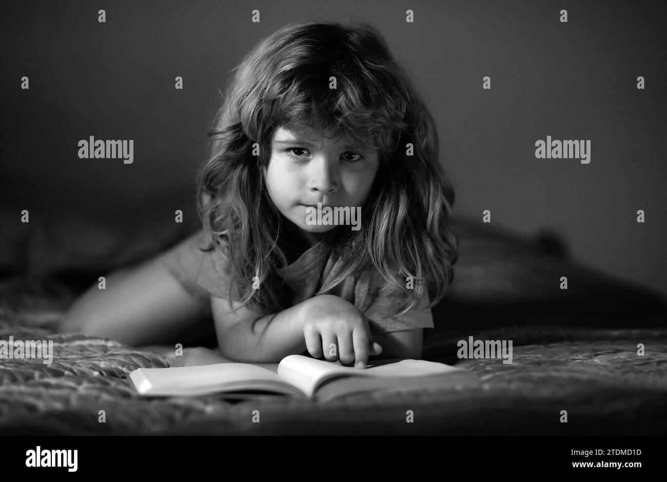 Kids reading a book in the dark home. Kids face with night light