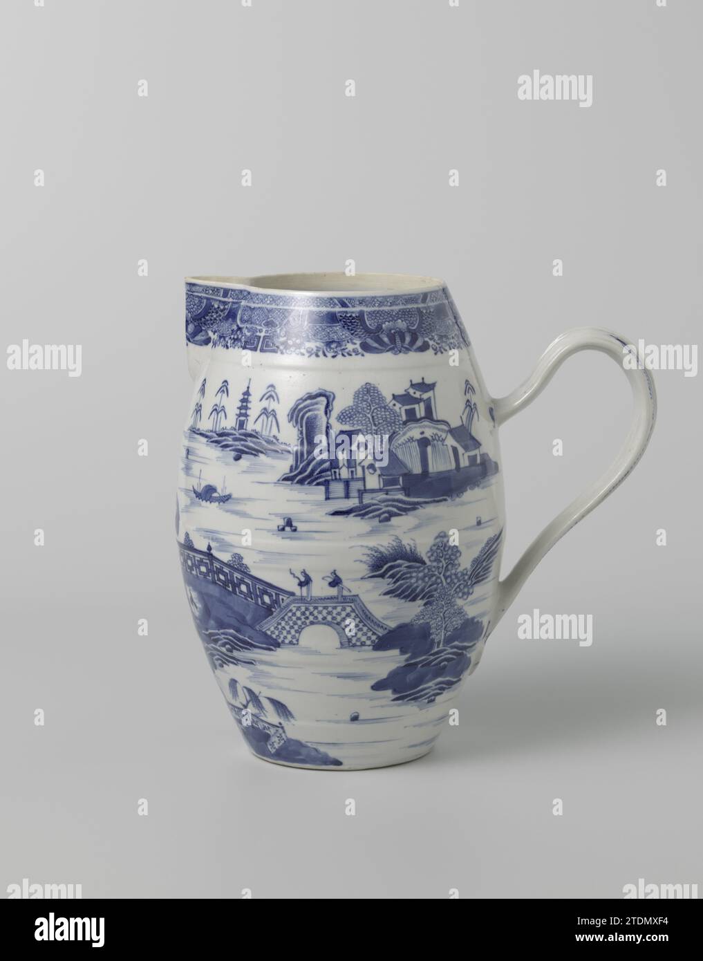 Pitcher with a riverlandscape with large pavilion and figures, c. 1800 - c. 1824 Can be made of porcelain with a barrel -shaped abdomen, triangular spout from the edge and ear, painted in underlaze blue. On the wall of the Kan a continuous river landscape with pavilions, mountains, trees, people and a boat; the edge with Fitzhugh band; A slender on the ear. Bijhehoor lid has number AK-NM-6944-A. Blue White. China porcelain. glaze. cobalt (mineral) painting / vitrification Can be made of porcelain with a barrel -shaped abdomen, triangular spout from the edge and ear, painted in underlaze blue. Stock Photo
