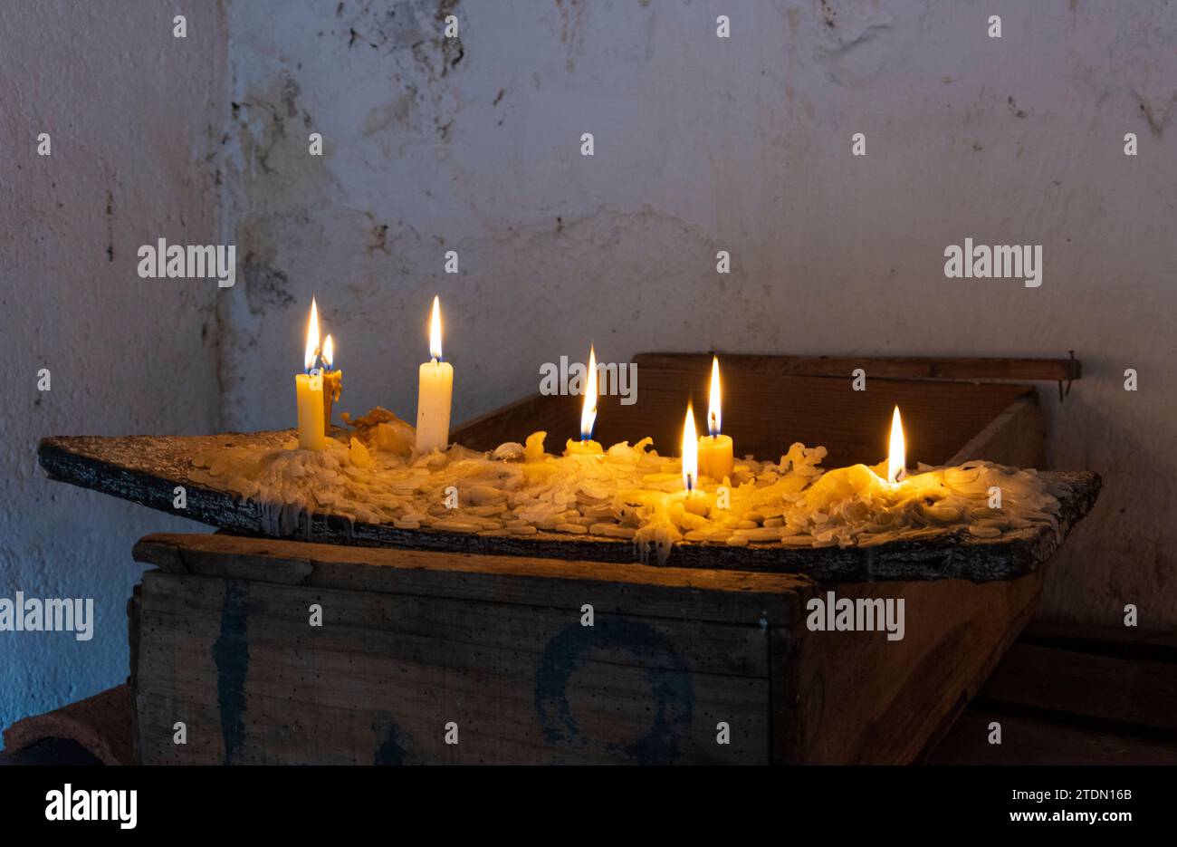 Candles lit on an old piece of wood. Chirche traditions day. Old wooden box. warm atmosphere Stock Photo