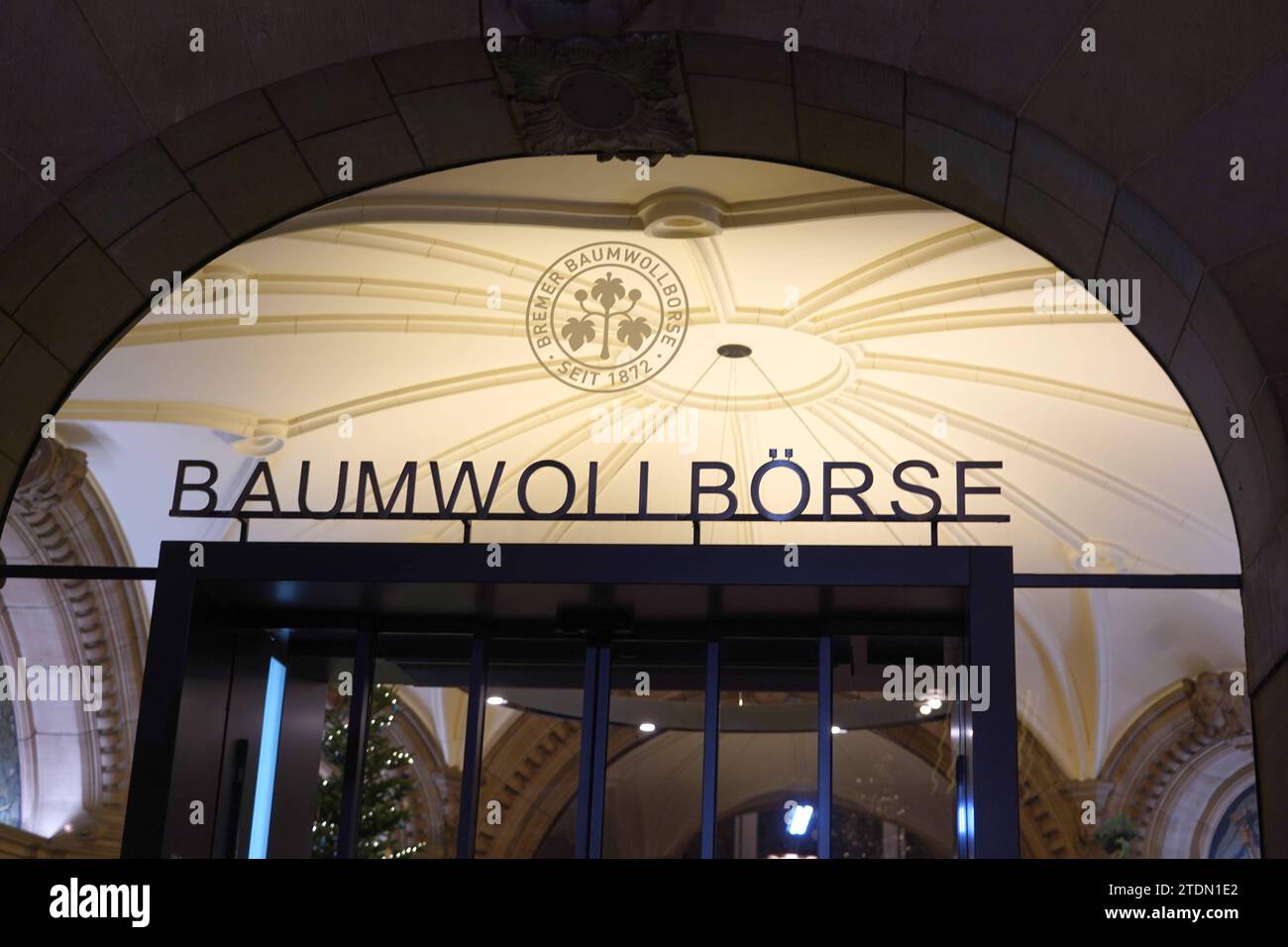 Das Eingangsportal der Bremer Baumwollbörse BBB bei Nacht. Das Gebäude wurde 1902 in der Bremer Innenstadt eingeweiht. Die BBB ist ein rechtsfähiger wirtschaftlicher Verein kraft staatlicher Verleihung und geht zurück auf ein 1872 gegründetes Komitee für den Baumwollhandel. Sie bezeichnet sich als geÂmeinÂsaÂmen VerÂband von Baumwollproduzenten, verarbeitendem Gewerbe und Handel. Hier wird allerdings nicht wie an einer Börse gehandelt, sondern die BBB legt international anerkannte Standards für den Baumwollhandel fest, betätigt sich als Schiedsgericht, berät ihre Mitglieder und vertritt die In Stock Photo