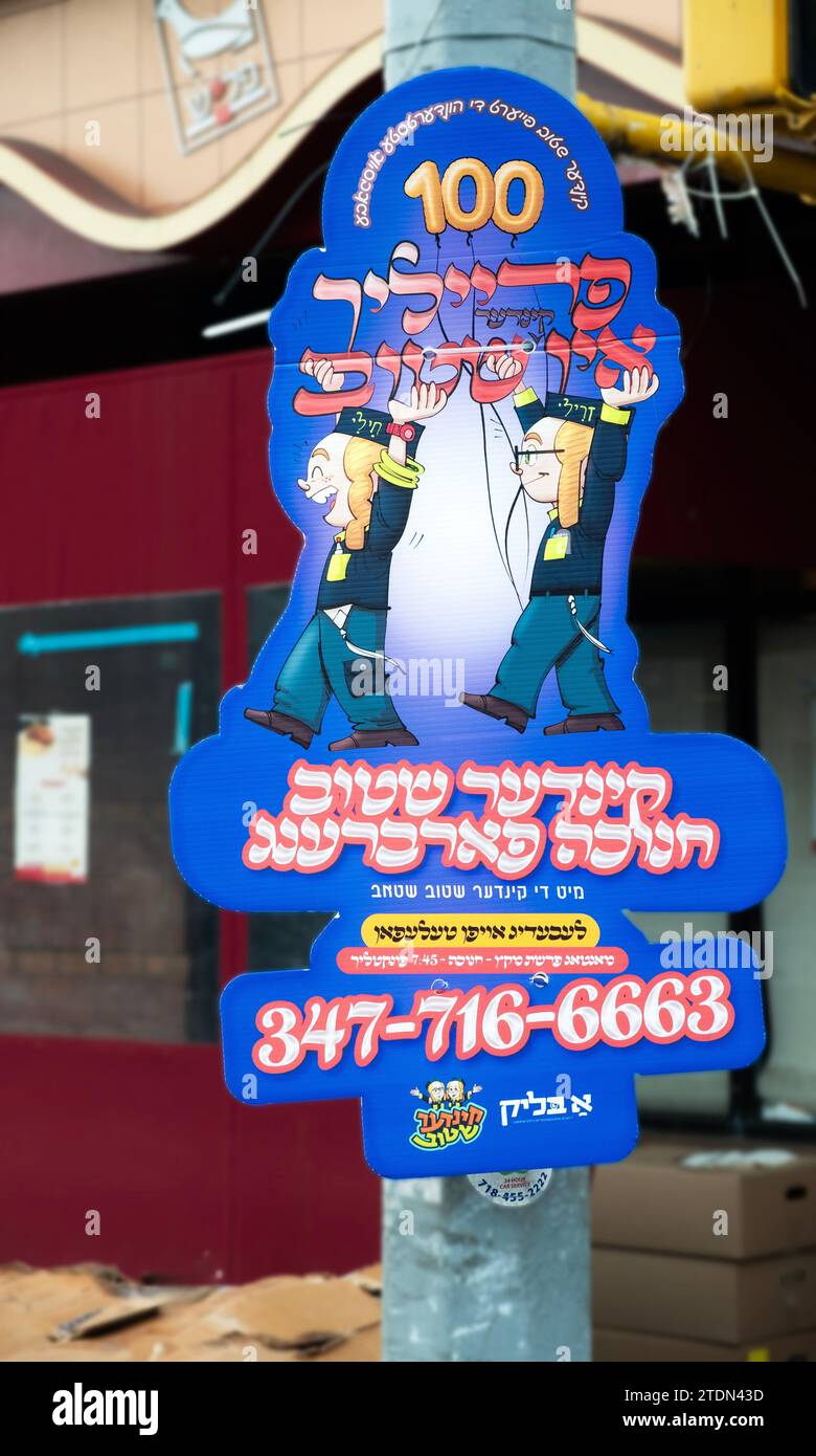 A colorful sign in beautiful Yiddish script inviting children ti join a Chanukkah farbrengen, a phone gathering to discuss Hasidic laws & customs. Stock Photo