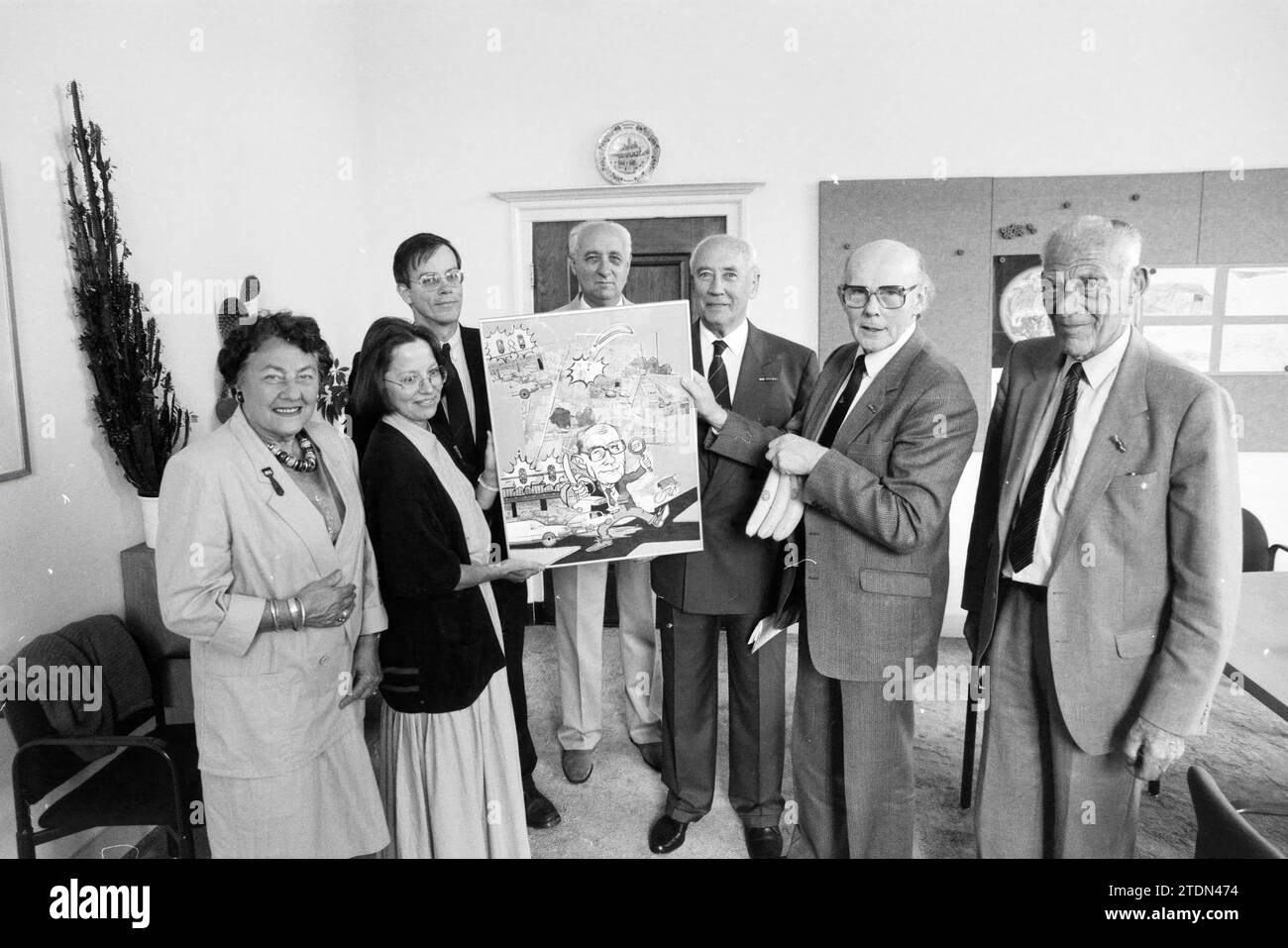 Man in Heemstede town hall receives framed cartoon with traffic theme (group portrait), Heemstede, The Netherlands, 25-04-1990, Whizgle News from the Past, Tailored for the Future. Explore historical narratives, Dutch The Netherlands agency image with a modern perspective, bridging the gap between yesterday's events and tomorrow's insights. A timeless journey shaping the stories that shape our future Stock Photo