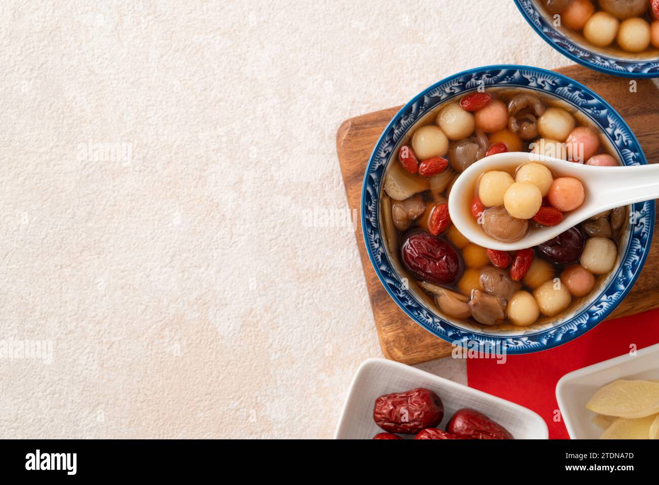 Little homemade red and white tangyuan, tang yuan, rice dumpling balls, with sweet syrup soup and dried longan pulp for Winter solstice festival. Stock Photo