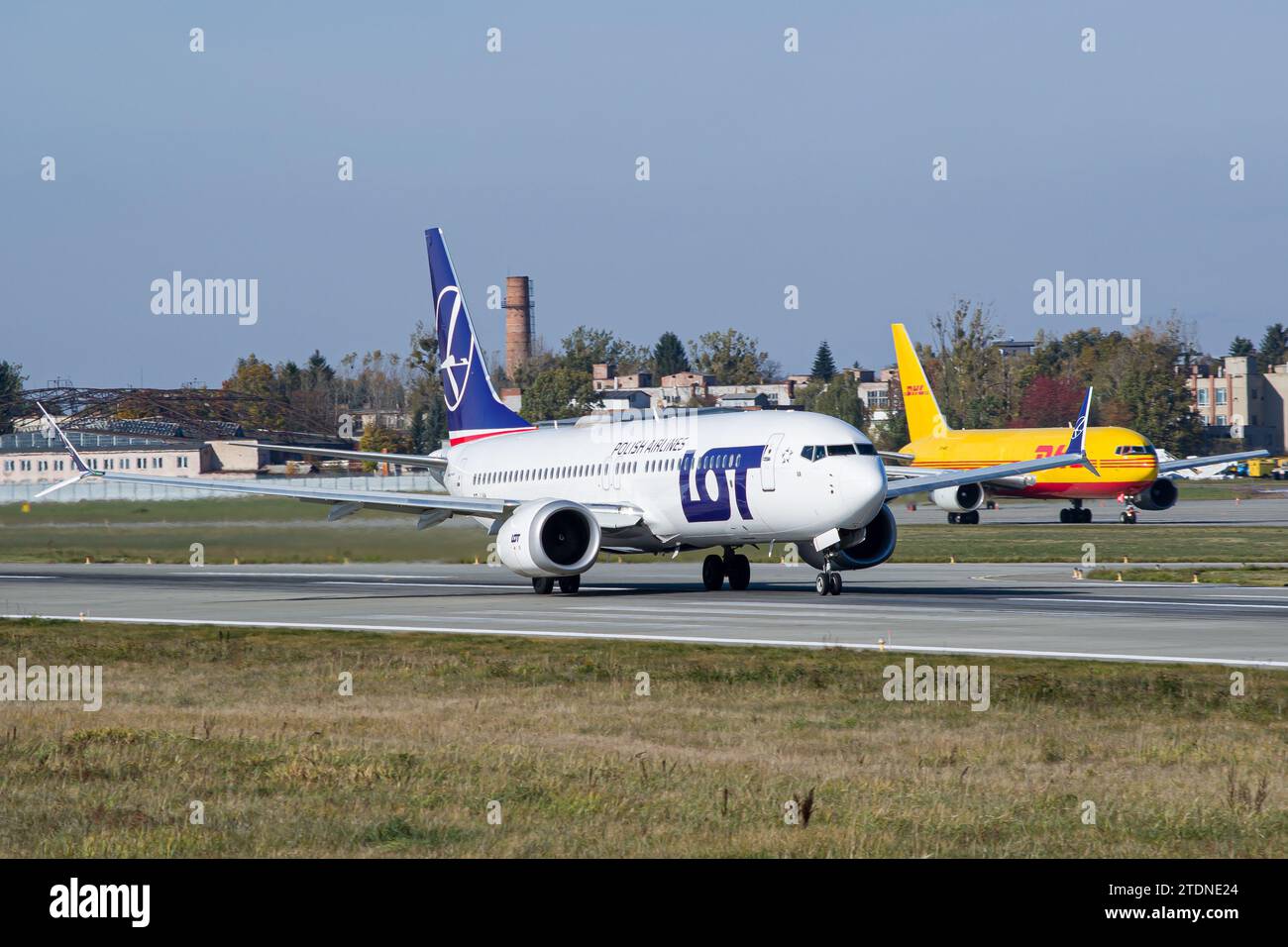 LOT Polish Airlines Boeing 737 MAX 8 slowing down after landing in Lviv after a flight from Warsaw, Poland. DHL Boeing 767-200F in the background Stock Photo