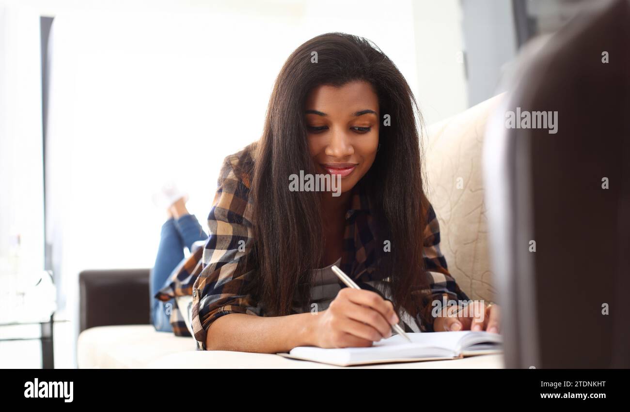Smiling black woman write story in notebook Stock Photo - Alamy