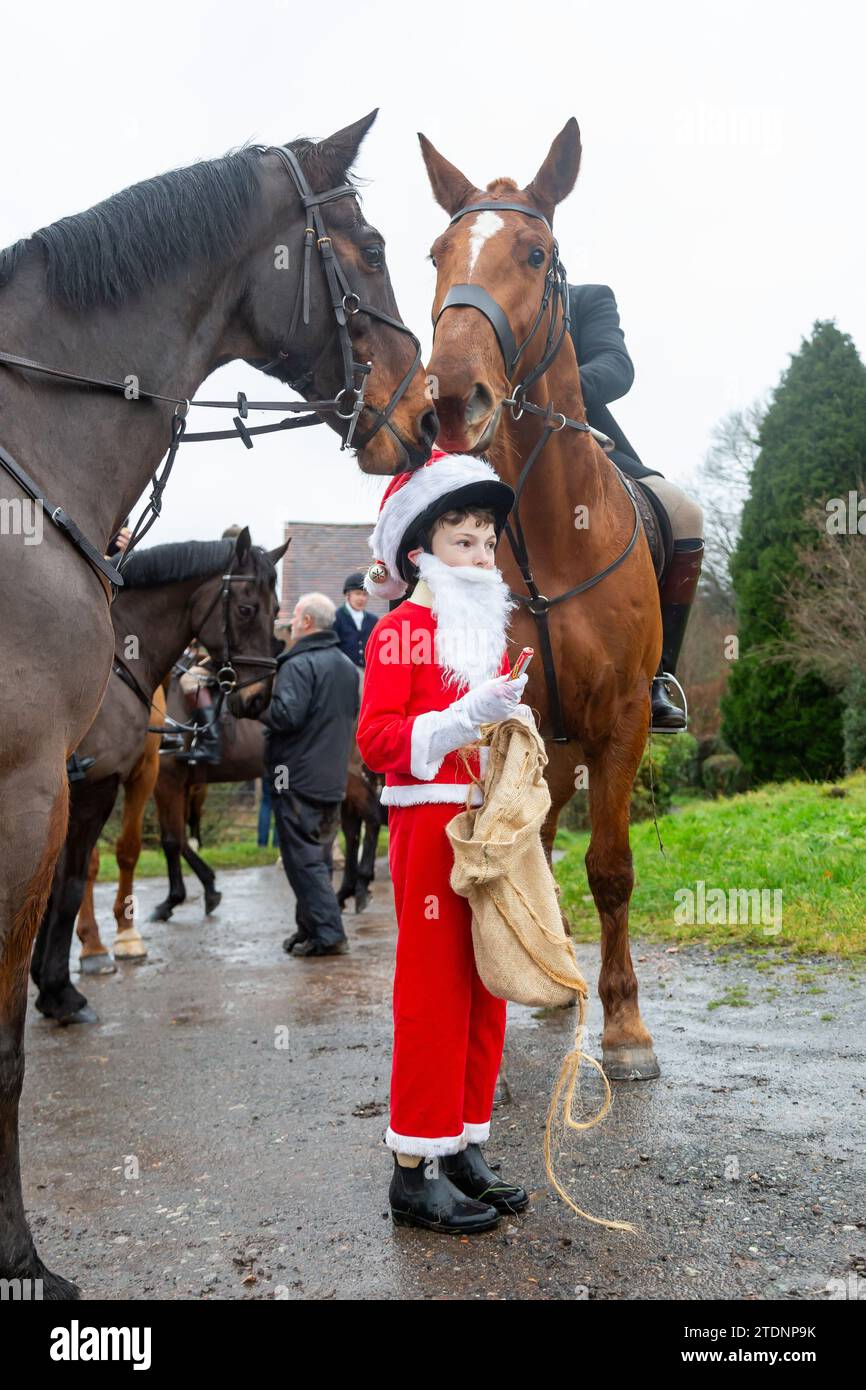 Upper Arley, Kidderminster, Worcestershire, UK. 19th Dec, 2023. 10-year-old Henley Mills dressed as Santa Claus hands out chocolate bars to members of the Albrighton and Woodland hunt as they have a lawn meet and trail ride from a farm in Upper Arley, near Kidderminster in Worcestershire. Credit: Peter Lopeman/Alamy Live News Stock Photo