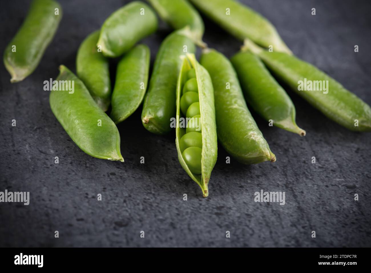 green peeled peas in a bowl on black background Stock Photo