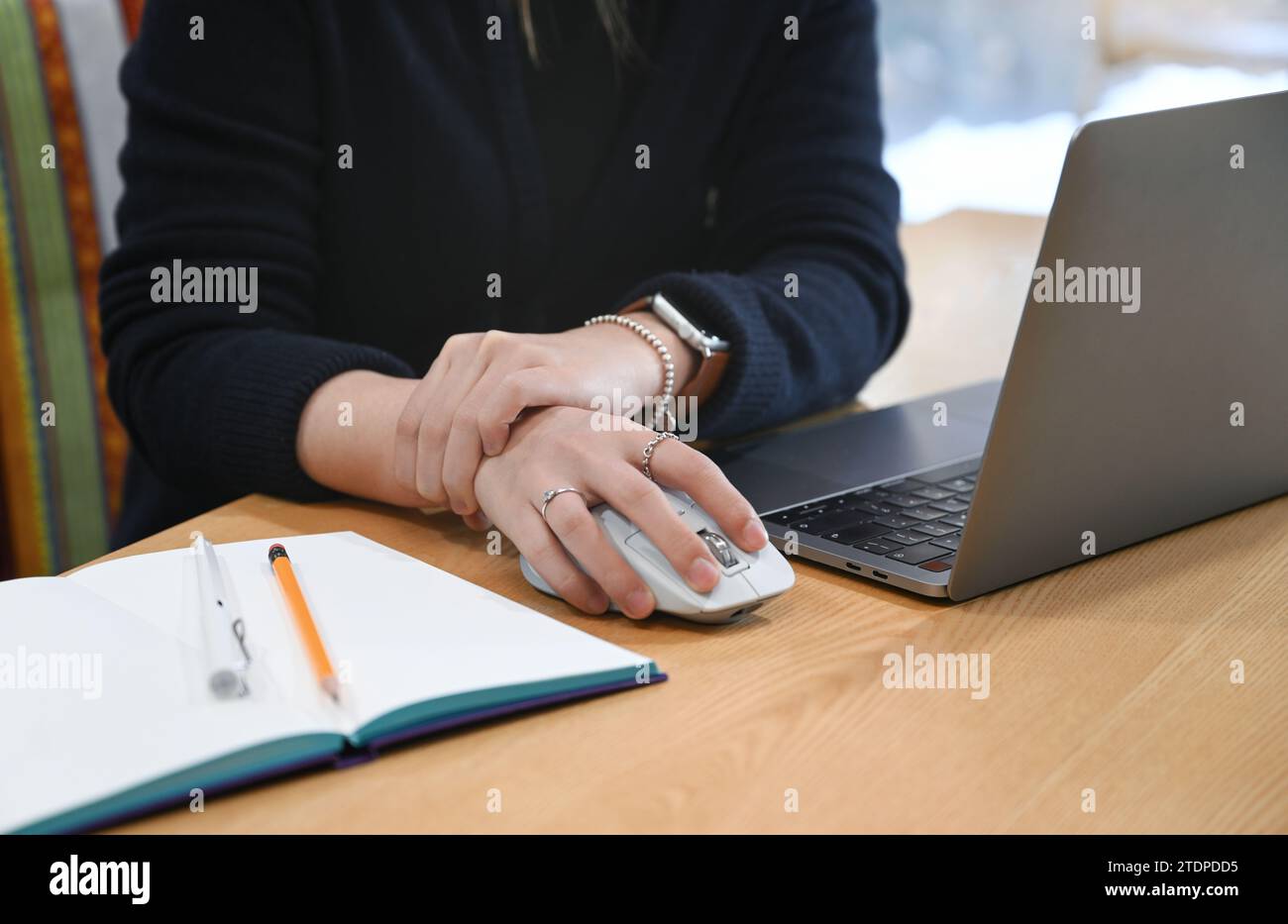 A woman working at a desk using a laptop and mouse is complaining of ...